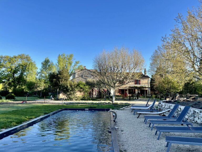 L'image est une photo prise au Mas des Jonquiers, lieu du séjour. Gros plan sur la piscine et maison dans le fond.